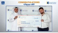Doha Bank official awarding the winner of Al Dana draw.