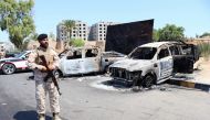 A member of the Libyan armed unit, 444 Brigade, backing the Government of National Unity (GNU) and its Prime Minister Abdulhamid al-Dbeibah, stands in front of burned vehicles in Ain Zara area in Tripoli, Libya, July 22, 2022. (REUTERS/Hazem Ahmed)