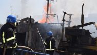 Firefighters work at a site of a Russian missile strike in a sea port of Odesa, as Russia's attack on Ukraine continues, Ukraine July 23, 2022. (Handout via REUTERS)