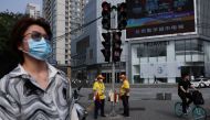 People wait at an intersection on a street during morning rush hour, in Beijing's Central Business District, China, August 2, 2022. (REUTERS/Tingshu Wang)