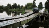A van from the Soviet Union era is driven by a resident on a bridge rebuilt by Ukrainian militaries, after a military strike on it near the small village of Malaya Rohan, amid Russia's invasion of Ukraine, in Kharkiv region, Ukraine, August 4, 2022. (REUTERS/Nacho Doce)