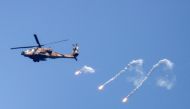 An Israeli Air Force Apache helicopter fires flares in the sky above the Israel-Gaza border on August 7, 2022. (REUTERS/Amir Cohen)