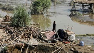 A flood victim stands amid the damages of his house, following rains and floods during the monsoon season, in Nowshera, Pakistan, on August 31, 2022. REUTERS/Fayaz Aziz/File Photo