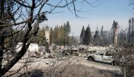 A burned car stands near a burned down home in the aftermath of the Mill Fire, in Weed, California, on September 3, 2022. REUTERS/Fred Greaves