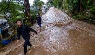 People wade through water on a flooded street in the aftermath of Hurricane Fiona in Salinas, Puerto Rico September 19, 2022. Reuters/Ricardo Arduengo