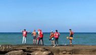 Members of Syrian Red Crescent stand by a shoreline following a migrant boat, which according to Lebanese and Syrian officials, sank off the Syrian coast after sailing from Lebanon, in Tartous, Syria on September 24, 2022. Courtesy of Syrian Red Crescent/Handout via REUTERS