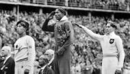 Photo credit: On August 11, 1936, America's Jesse Owens salutes during the presentation of his gold medal for the long jump, alongside silver medalist Luz Long (right) of Germany, and bronze medalist Naoto Tajima of Japan during the 1936 Summer Olympics in Berlin. (AP Photo/File)