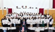 A group photo of students with officials at The White Coat ceremony of the College of Medicine at Qatar University.