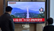 People watch a television screen showing a news broadcast with file footage of a North Korean missile test, at a railway station in Seoul on November 2, 2022. Photo by JUNG YEON-JE / AFP