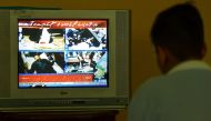 A boy watches a television channel showing the news of Pakistan's former prime minister Imran Khan, in Islamabad, on November 3, 2022. (Photo by Farooq NAEEM / AFP)