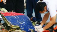 An officer of Indonesia's National Transportation Safety Committee takes pictures of the remains of Sriwijaya Air flight SJ 182, which crashed into the Java Sea, on the last day of its search and rescue operation, at Tanjung Priok port in Jakarta, Indonesia, January 21, 2021. REUTERS/Ajeng Dinar Ulfiana