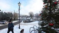 A man walks a dog in Braemar, Scotland, Britain December 13, 2022. REUTERS/Russell Cheyne