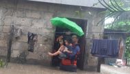 This handout photo taken on December 25, 2022 and received on December 26 from the Philippine Coast Guard shows rescuers evacuating a child from a flooded area in Ozamiz City, Misamis Occidental. Photo by Handout / Philippine Coast Guard (PCG) / AFP)