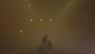 A man walks across a smoggy road on a cold winter morning in New Delhi, India, December 27, 2022. REUTERS/Anushree Fadnavis