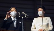 Japan's Emperor Naruhito (L) and Empress Masako (R) wave to well-wishers through a bullet-proof glass from a balcony during their New Year's public appearance at the Imperial Palace in central Tokyo, Japan, 02 January 2023. FRANCK ROBICHON/Pool via REUTERS