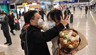 A passenger receives a hug while leaving the arrival area of international flights at the Shanghai Pudong International Airport, in Shanghai on January 8, 2023.(Photo by Hector Retamal / AFP)