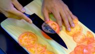 This picture taken on September 2, 2022 shows a demonstration to test the sharpness of a knife with a tomato at a factory of Sumikama Cutlery in Seki, Gifu prefecture.(Photo by Kazuhiro Nogi / AFP)