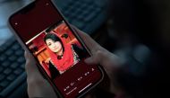A woman looks at a picture of former Afghan lawmaker Mursal Nabizada on her mobile phone, who was shot dead by gunmen last night at her house in Kabul on January 15, 2023. (Photo by Wakil Kohsar / AFP)