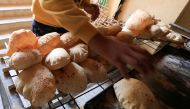 An Egyptian worker removes loaves of bread from the oven at a bakery in Cairo's southeastern Mokattam district, as the prices of basic goods in Egypt have risen since Russia’s invasion of Ukraine, in Egypt, March 16, 2022. (REUTERS/Amr Abdallah Dalsh)