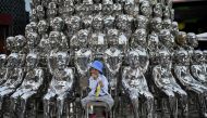 In this file photo taken on June 1, 2021 a boy sits on a chair amongst sculptures on display at a shopping centre on International Children's Day in Beijing.  (Photo by Noel Celis / AFP)