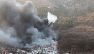 Firefighters try to extinguish a fire at the Guryong village, one of South Korea's last remaining slums, in southern Seoul on January 20, 2023. Photo by YONHAP / AFP