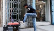 A man starts a generator outside his shop during a country-wide power breakdown in Karachi, Pakistan January 23, 2023. File Photo: Reuters/Akhtar Soomro
