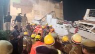 Rescue workers assist a man to a safer place after he was rescued from the debris of a collapsed residential apartment block in Lucknow, India, January 24, 2023. (REUTERS/Saurabh Sharma)