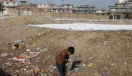 An Afghan child collects plastic to burn for heat in Kabul, Afghanistan, January 26, 2023. REUTERS/Ali Khara
