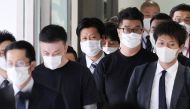 Toshiya Fujita (2nd L) and Kiyoto Imamura (front 2nd R, with glasses), members of a group of suspects believed to be behind a spate of robberies and telephone fraud cases across Japan, are escorted upon their arrival following their deportation from the Philippines at Narita International Airport in Chiba prefecture, outside Tokyo, on February 7, 2023.