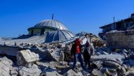 Local residents walk in the rubble of a destroyed mosque in Hatay, on February 10, 2023, after the 7.8 magnitude earthquake that killed over 20,000 people. (Photo by Yasin AKGUL / AFP)
 
