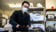 This photo taken on January 19, 2023 shows Yoshimasa Kanno, operator of the Minatoya hotel, preparing tiger puffer fish at his hotel in Soma city of Japan's Fukushima Prefecture. Photo by Philip FONG / AFP