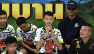 In this file photo taken on July 18, 2018 Duangpetch Promthep (C), one of the 12 boys rescued from deep inside a Thai cave after being trapped for more than a fortnight, speaks during a press conference in Chiang Rai following their discharge from hospital. Photo by LILLIAN SUWANRUMPHA / AFP