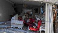 TOPSHOT - A cat sits on an armchair in a heavily damaged living room of a collapsed building in Hatay on February 15, 2023, nine days after a 7,8-magnitude earthquake struck parts of Turkey and Syria. (Photo by BULENT KILIC / AFP)
