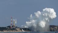 White smoke emerges from the main engines of the next-generation H3 rocket (L) as it fails to lift off the launch pad at the Tanegashima Space Center in southwestern Japan on February 17, 2023. Photo by JIJI Press / AFP


