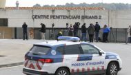 A police car is seen next to journalists informing outside the prison in San Esteve Sesrovires, 40 km from Barcelona, where Brazilian football player Dani Alves is jailed, on February 21, 2023. - Former Barcelona defender Dani Alves will remain in preventative custody pending his trial for alleged rape as he is considered a high flight risk, the Provincial Court of Barcelona decided today. (Photo by Josep LAGO / AFP)
 