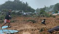 This handout photo taken and released on March 6, 2023 by the BNPB (National Disaster Management Agency) shows people inspecting the damage at a village that was hit by landslides in Natuna in Indonesia's Riau Province. (Photo by Handout / BNPB / AFP) 