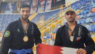 Qatar's medal-winning athletes pose with the national flag.