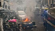 This photo obtained from Italian news agency Ansa shows a police car (Front) burn as Eintracht Frankfurt fans (not in picture) clash with police on March 15, 2023 in downtown Naples prior to the UEFA Champions League round of 16, second leg football match between SSC Napoli and Eintracht Frankfurt to be played at the Diego-Maradona stadium in Naples. Eintracht Frankfurt fans clashed with police on March 15 after arriving in Naples despite not having tickets for their team's Champions League decider with Napoli. (Photo by Ciro FUSCO / ANSA / AFP) 