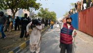 Pakistan's former Prime Minister Imran Khan's supporters run as police fire tear gas to disperse them outside a court in Islamabad on March 18, 2023.  (Photo by Farooq NAEEM / AFP)
 