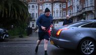 Former British Prime Minister Boris Johnson returns to his house after a run, in London on March 22, 2023. (Photo by JUSTIN TALLIS / AFP)