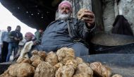 In this file photo a merchant presents a desert truffles at a market in the city of Hama in west-central Syria on March 6, 2023. (Photo by Louai Beshara / AFP)