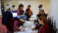 Voters receive their ballot papers at a polling station during Turkmenistan's parliamentary elections in the town of Annau, 20 km off the capital Ashgabat, on March 26, 2023. (Photo by Igor SASIN / AFP)