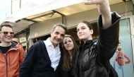 Greece's Prime Minister Kyriakos Mitsotakis takes a selfie photograph during a visit in the region of Evros to campaign and to sign the extension of the border fence project, in Didymoteicho, eastern Greece, on March 31, 2023.(Photo by Sakis Mitrolidis / AFP)