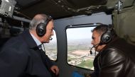 This handout photograph made available by Turkiye's Ministry of Defence on April 4, 2023, shows Turkish Minister of National Defense Hulusi Akar (left) talking with Greek Defence Minister Nikolaos Panagiotopoulos aboard a helicopter flying over Hatay province on April 4, 2023. (Photo by Handout / Turkish Defence Ministry / AFP)
