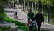 People walk in a public park in Beijing on April 15, 2023. Photo by WANG Zhao / AFP