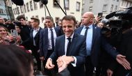 French President Emmanuel Macron shakes hands with people during a visit in Selestat, eastern France, on April 19, 2023. (Photo by Frederick Florin / AFP)