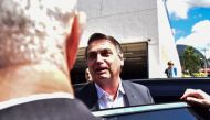 Brazilian former President Jair Bolsonaro speaks to the press while leaving the Federal Police headquarters after testifying in Brasilia on April 26, 2023. (Photo by TON MOLINA / AFP)
