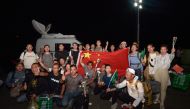 Chinese citizens evacuated from Sudan deploy a large national flag and upon their arrival at King Faisal navy base in Jeddah on April 26, 2023. Photo by Amer HILABI / AFP