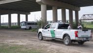 Two migrants are transported by US Customs and Border Patrol, under a bridge that connects the US and Mexico, in Eagle Pass, Texas, on May 10, 2023.  (Photo by ANDREW CABALLERO-REYNOLDS / AFP)
