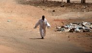 A man walks down a road in Khartoum amid ongoing fighting between the forces of two rival generals, on May 18, 2023. (Photo by AFP)